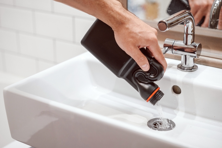 Use sodium hydroxide on the clogged bathroom sink.